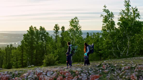 Drone Shot of Young Parents with Two Young Children Hiking on a Mountain Trail