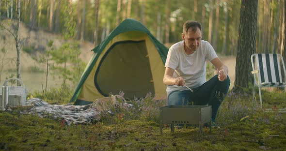 Tourist Is Living in Forest Camp Alone, Inflaming Coal in Chargrill for Cooking Dinner, Trip in alt