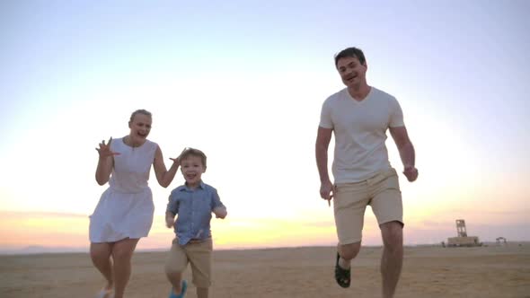 Parents having happy time with child on the beach alt