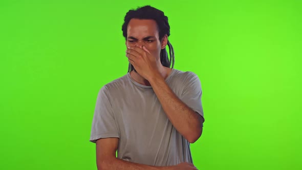 Young Ethnic African American Man Feels Unpleasant Odor Stands in Green Studio alt