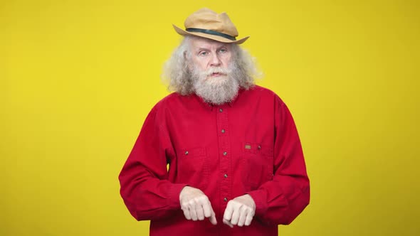 Serious Senior Caucasian Man Imitating Horse Riding at Yellow Background alt