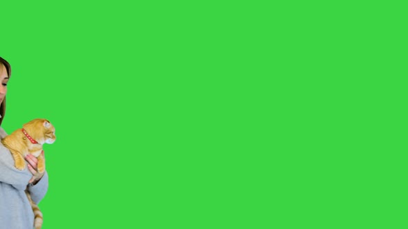 Girl Walking and Holding a Cat on a Green Screen Chroma Key