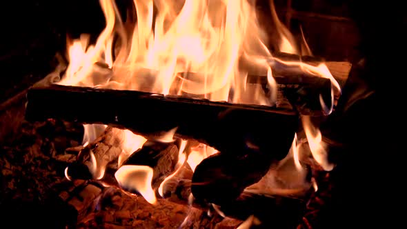 Hot fireplace full of wood. Real Flames from burning logs in slow motion.