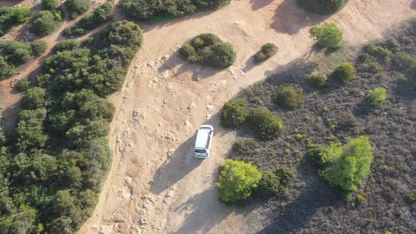 White van on dirt road approaching Fontainhas Beach in south Portugal with dogs and people walking, alt
