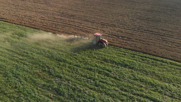 Farmer in Tractor Plows Field alt