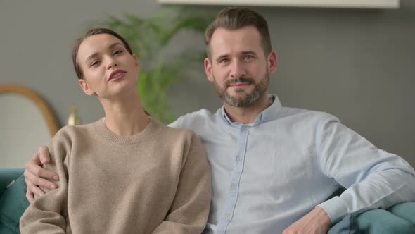 Couple Making Online Video Call While Sitting on Sofa alt