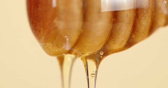 Fresh Honey Flows Down with a Wooden Spoon. 