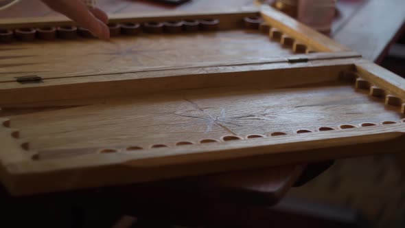 Human Hand Slowly Rolls the Dice Before Playing Backgammon on the Board