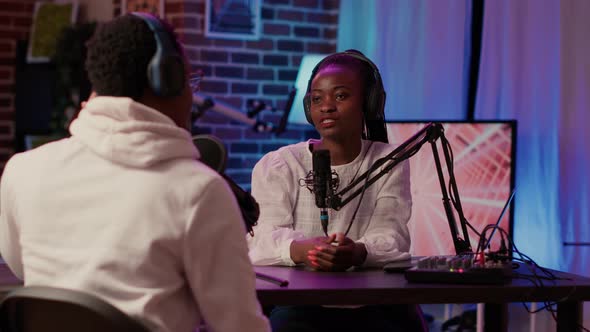 Closeup of African American Podcast Host Interviewing Male Influencer for Online Broadcast Using alt