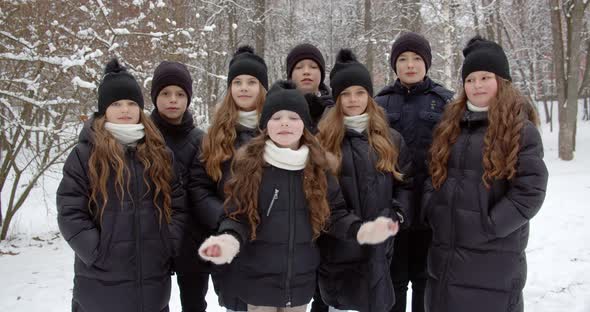 Children Gathered For A Walk In A Snowy Park