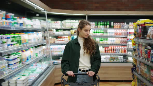 A Portrait of a Woman in a Supermarket Pushing Trolley alt