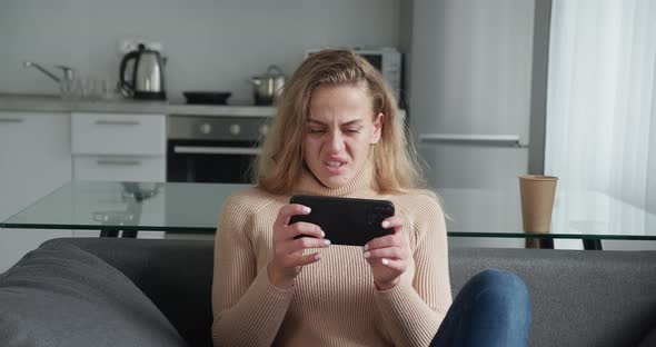 Young Woman Playing Video Games on Her Smartphone and Gets Angry As She Lose the Game alt