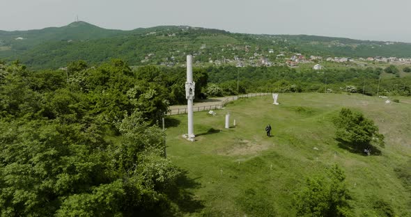 Simple monument surrounded by forest, commemorating fallen Georgian Junkers. alt