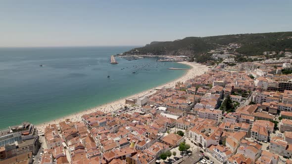 Sesimbra, aerial view of beach and cityscape against the marina and hills. alt