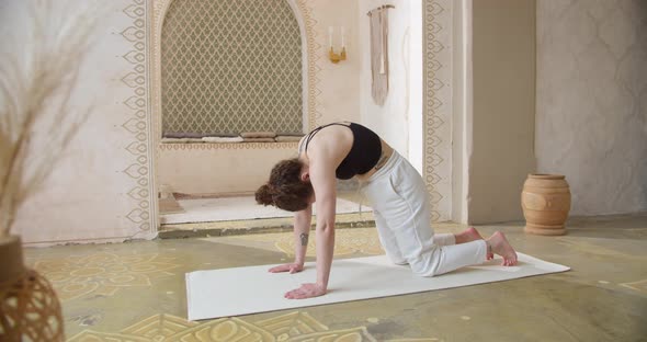 Sporty CurlyHaired Woman Does Yoga Stretching Exercises