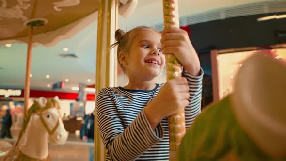 Close Up View of Smiling Girl Enjoying Riding on the Carousel