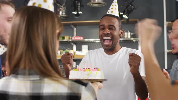 African American guy snuffing out cake candles