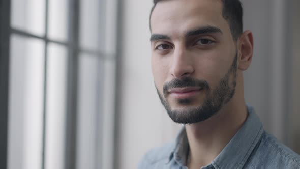Headshot of Young Confident Handsome Man Looking Out the Window Turning to Camera and Smiling alt
