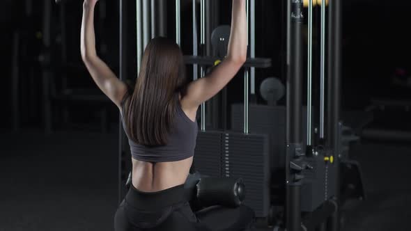Woman in the Gym Lifting Blocks on Rack Machine Strength Training on Block Device Cinematic Light alt