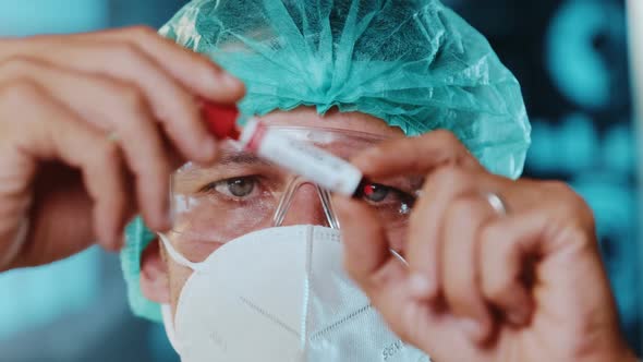 Laboratory Worker Examines Test Tube with Blood for Coronavirus Test alt