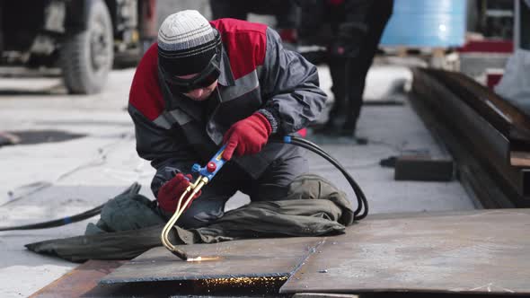 Factory Worker is Welding in Protective Helmets and Glasses