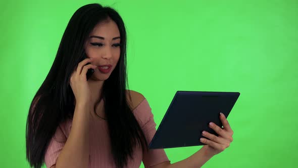 Young Attractive Asian Woman Phone and Works on Tablet - Green Screen Studio alt