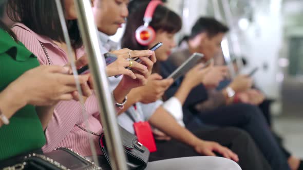 Young People Using Mobile Phone in Public Underground Train alt