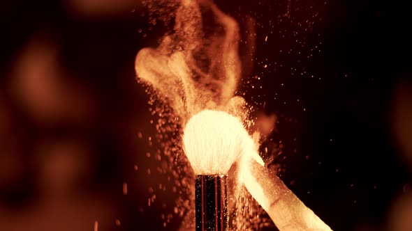 Gold Neon Glowing UV Powder on a Makeup Brush Flying Away in Slow Motion