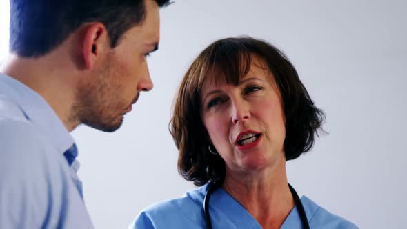 Doctors discussing over digital tablet in corridor alt