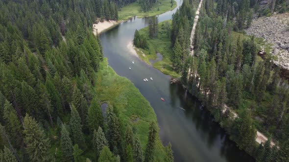 Paddleboarders and kayakers floating on the Payette River in the forest near McCall, Idaho. This stu alt