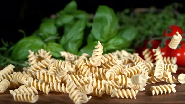 Super Slow Motion Shot of Fresh Fusilli Falling on Italian Decorated Wooden Table at 1000Fps alt