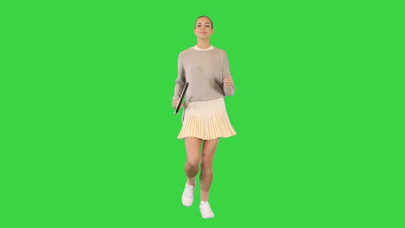 Beautiful Girl Running with a Tennis Racket on a Green Screen Chroma Key