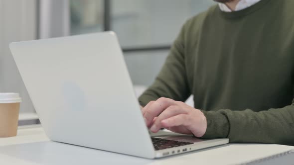 Close Up of Young Businessman Typing on Laptop alt