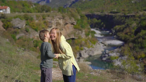A Handheld Shot of a Young Woman and Her Son That are Visiting the Moracica River Canyon in alt