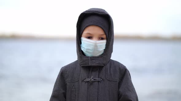Boy Medical Mask on His Face During Quarantine Stands on Beach During the Second Wave Quarantine alt