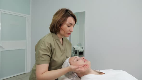 Beautician Does Professional Face Massage Side View alt