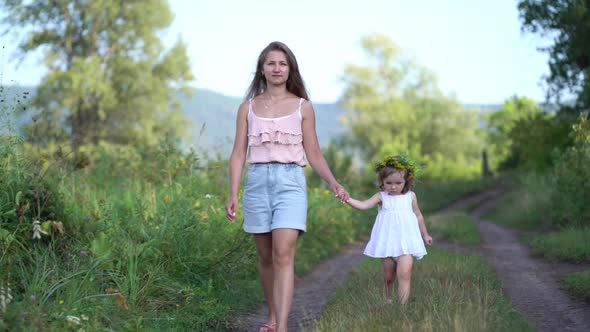 Happy Mother and Daughter with the Flower Wreath Walk in the Countryside alt