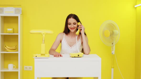 Young Woman Is Talking Phone In Beautiful Yellow Office alt