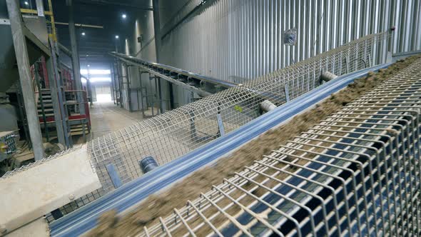 Rocks and Sand Moving on a Working Line at a Plant. alt