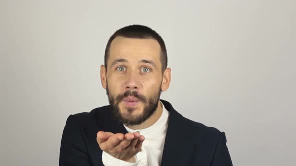 A Young Successful Businessman Smiles and Sends an Air Kiss alt