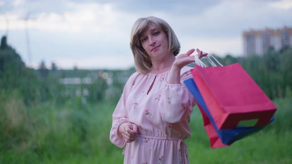 Medium Shot of Fashionable Stylish Trans Woman Hanging Shopping Bags on Shoulder in Slow Motion alt