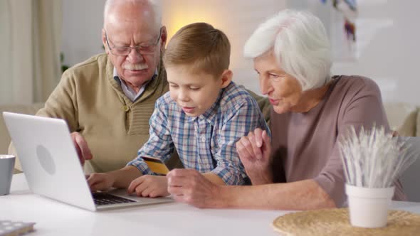 Boy Shopping Online Together with Grandparents alt