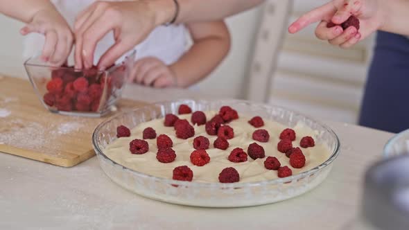 Childs with Mom Adding Raspberry To Dough. Mother with Kids Cooking Pie. alt