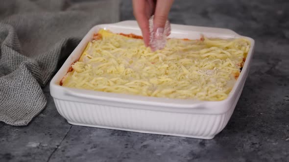 The Chef Cooks Italian Lasagna Sprinkled with Mozzarella