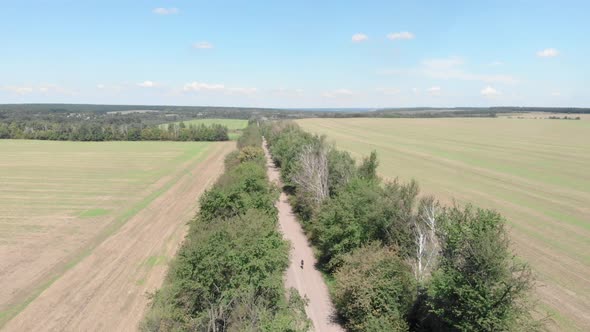 Woman riding gravel bicycle aerial view alt