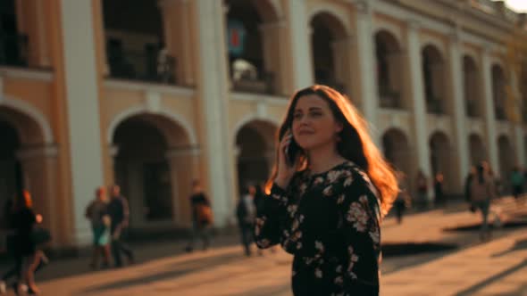 Charming Brunette Woman Calling By Smartphone and Running To Hug Her Boyfriend at Urban Street alt
