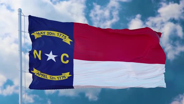 North Carolina Flag on a Flagpole Waving in the Wind Blue Sky Background alt