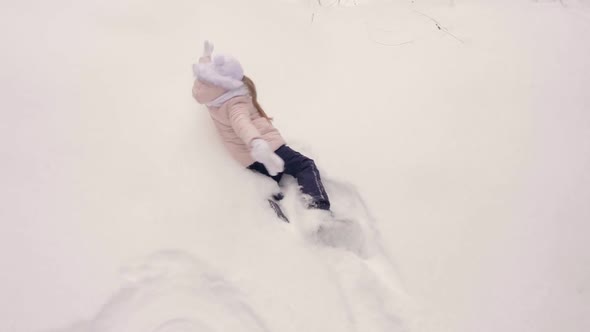 Young Girl in Coral Pink Jacket Walk and Fall to Snow Than Show Snow Angel Butterfly Movement of alt