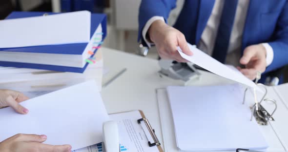 Man and Woman Sorting Documents with Hole Punch and Stapler and Putting Them in Folder  Movie alt