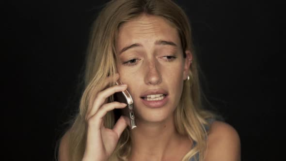 Woman having upsetting phone call on cell phone alt